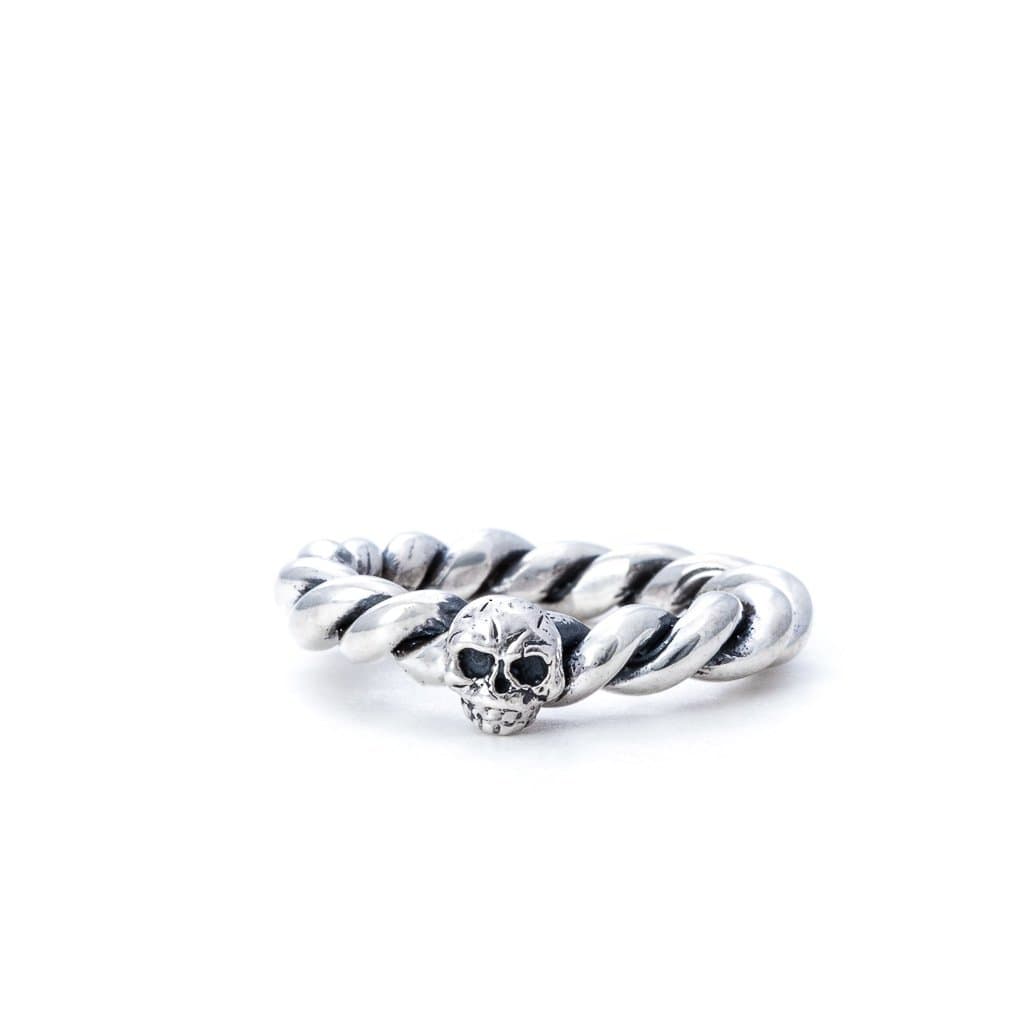 A sterling silver twisted rope ring with a skull design at the band's intersection, displayed against a white background.