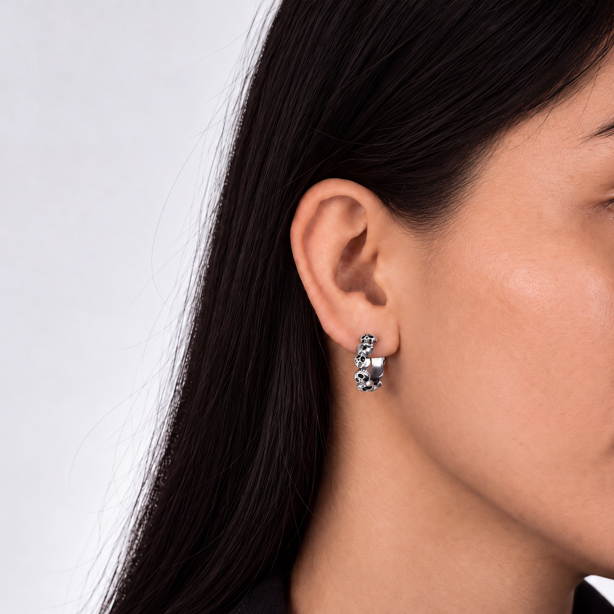Solid Sterling Silver hoops, Multiple skulls connected together in design on a model