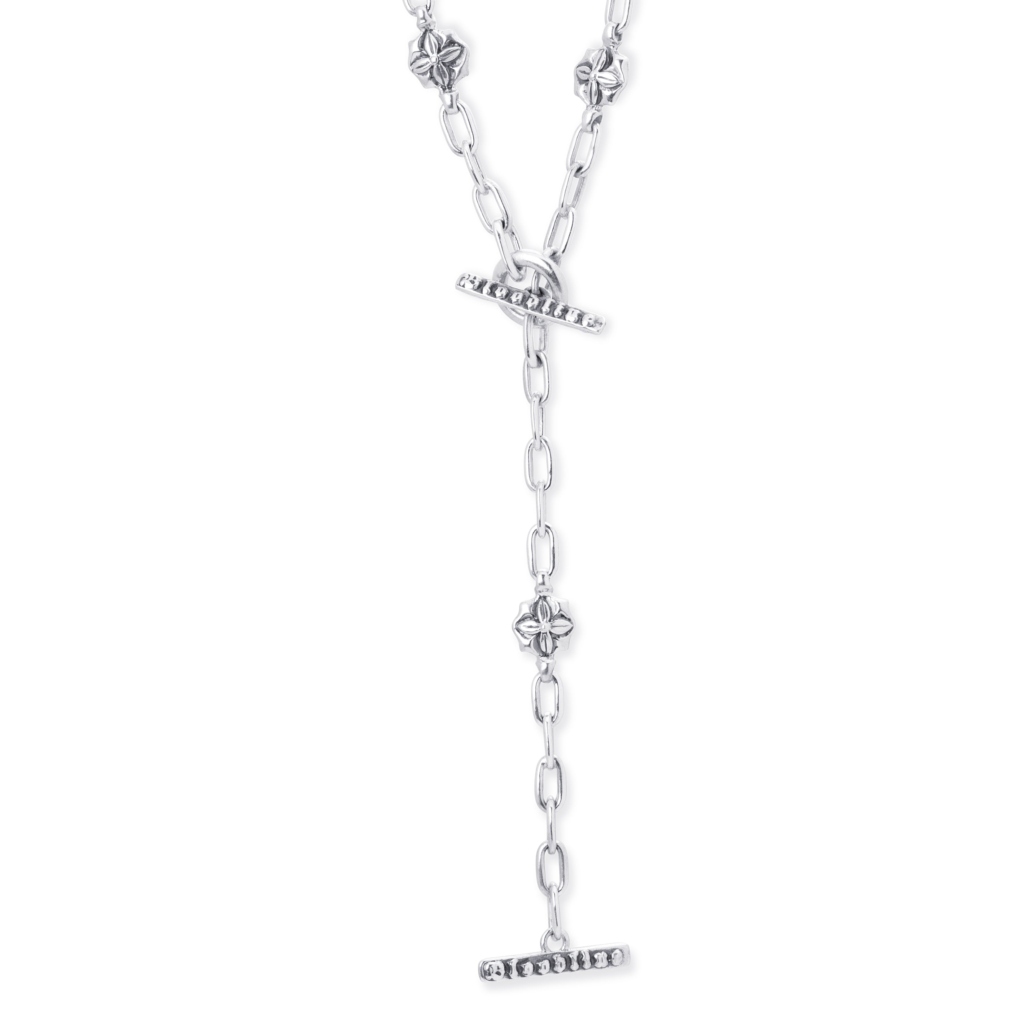 A silver lariat necklace featuring a short curb chain, a toggle clasp with small round floral links on a white background. 