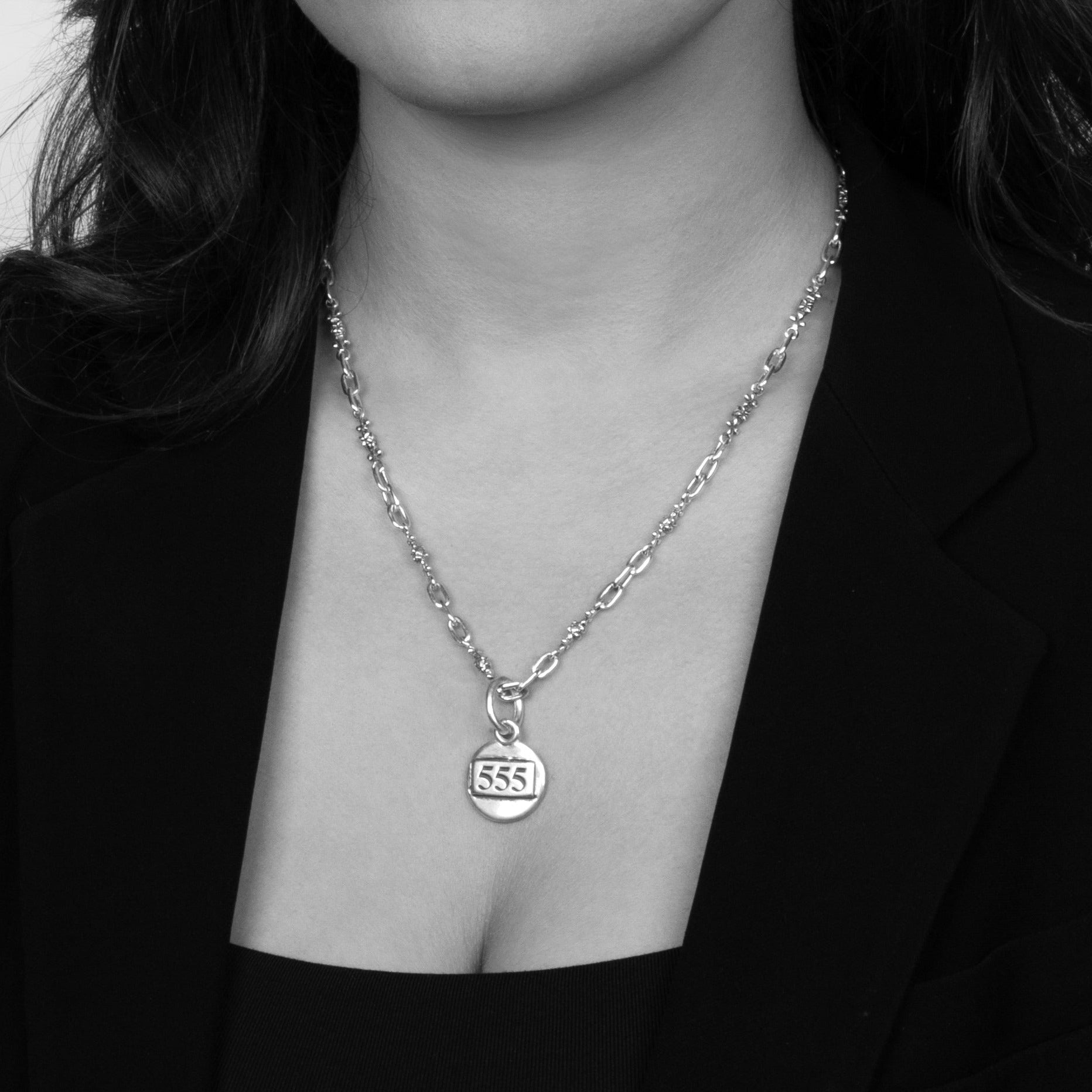 Solid Sterling Silver, centred with Angel Numbers on a plain coin shaped pendant shown on a model