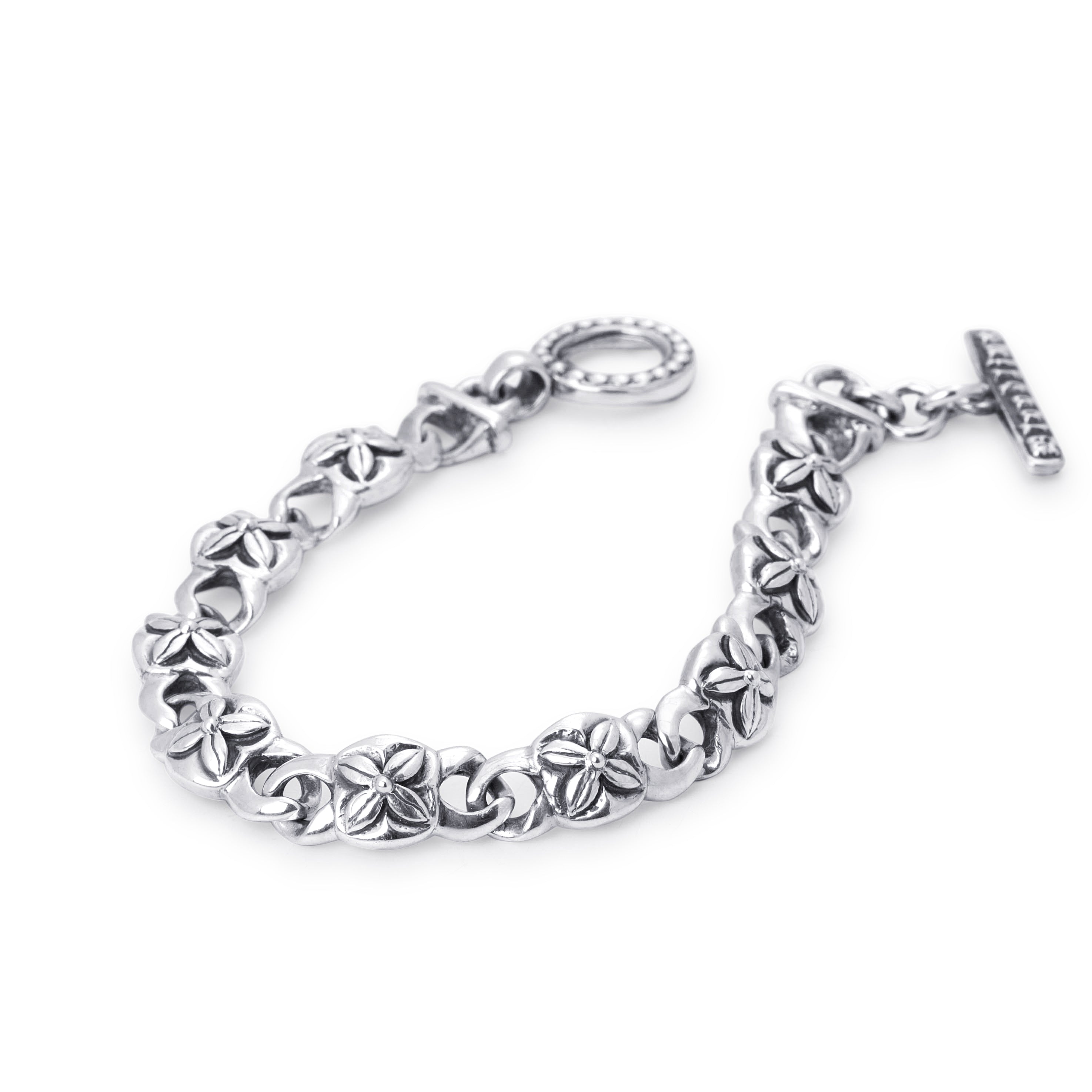A sterling silver chain bracelet with a textured floral link pattern, featuring a T clasp and a flat bar toggle clasp, shown on a plain white background.