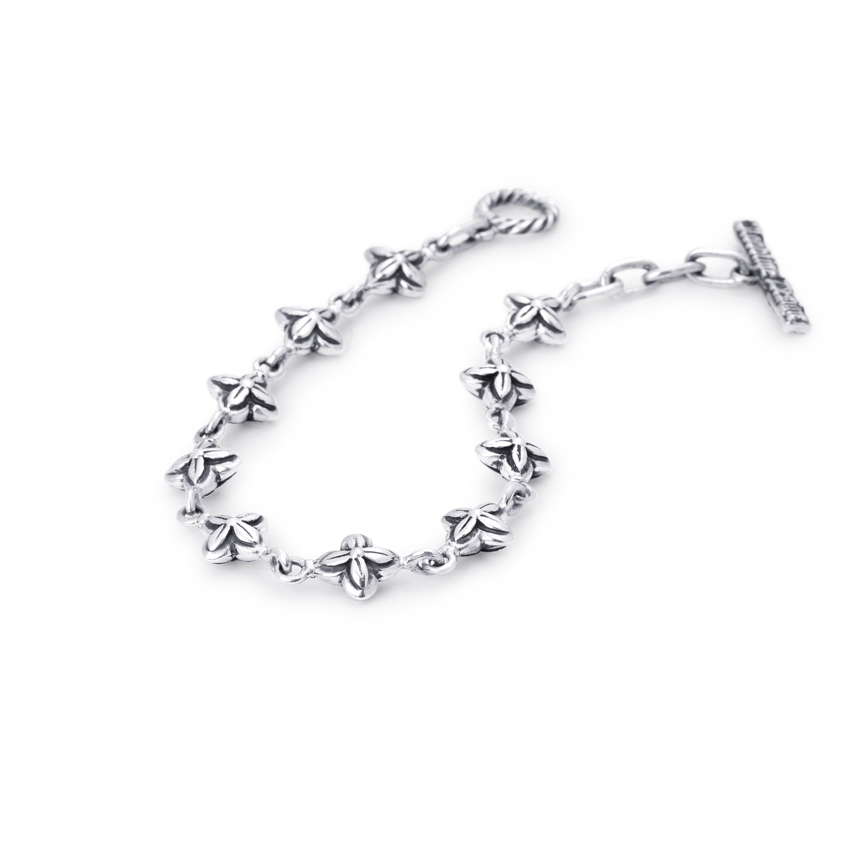 A silver-toned chain bracelet featuring small, detailed flower motifs along the chain, finished with a twisted lobster clasp on one end and an extension chain with a flat bar clasp on the other, shown against a plain white background.