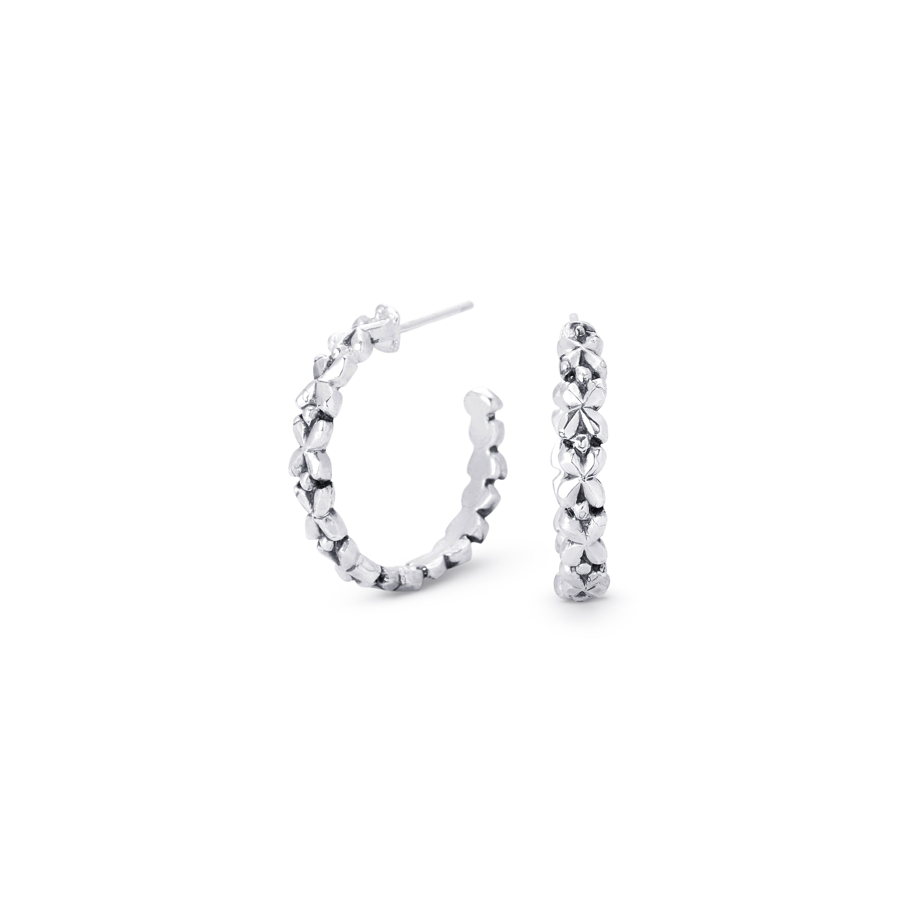 A pair of silver hoop earrings with a textured, floral design, shown on a plain white background.