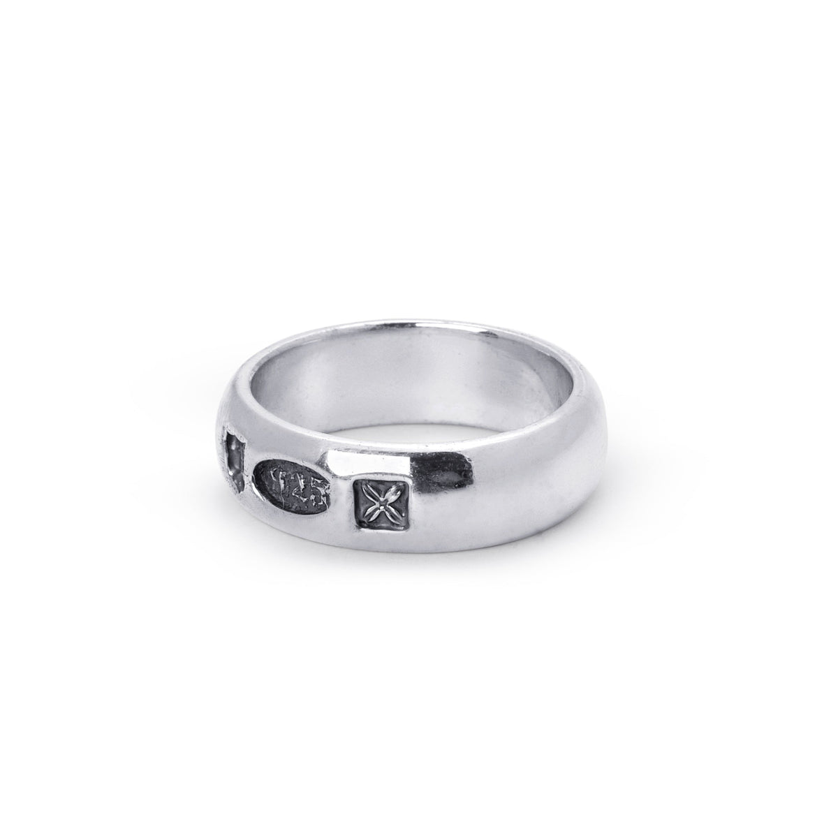 A silver band ring with three small dark hallmarks, photographed on a clean white background.