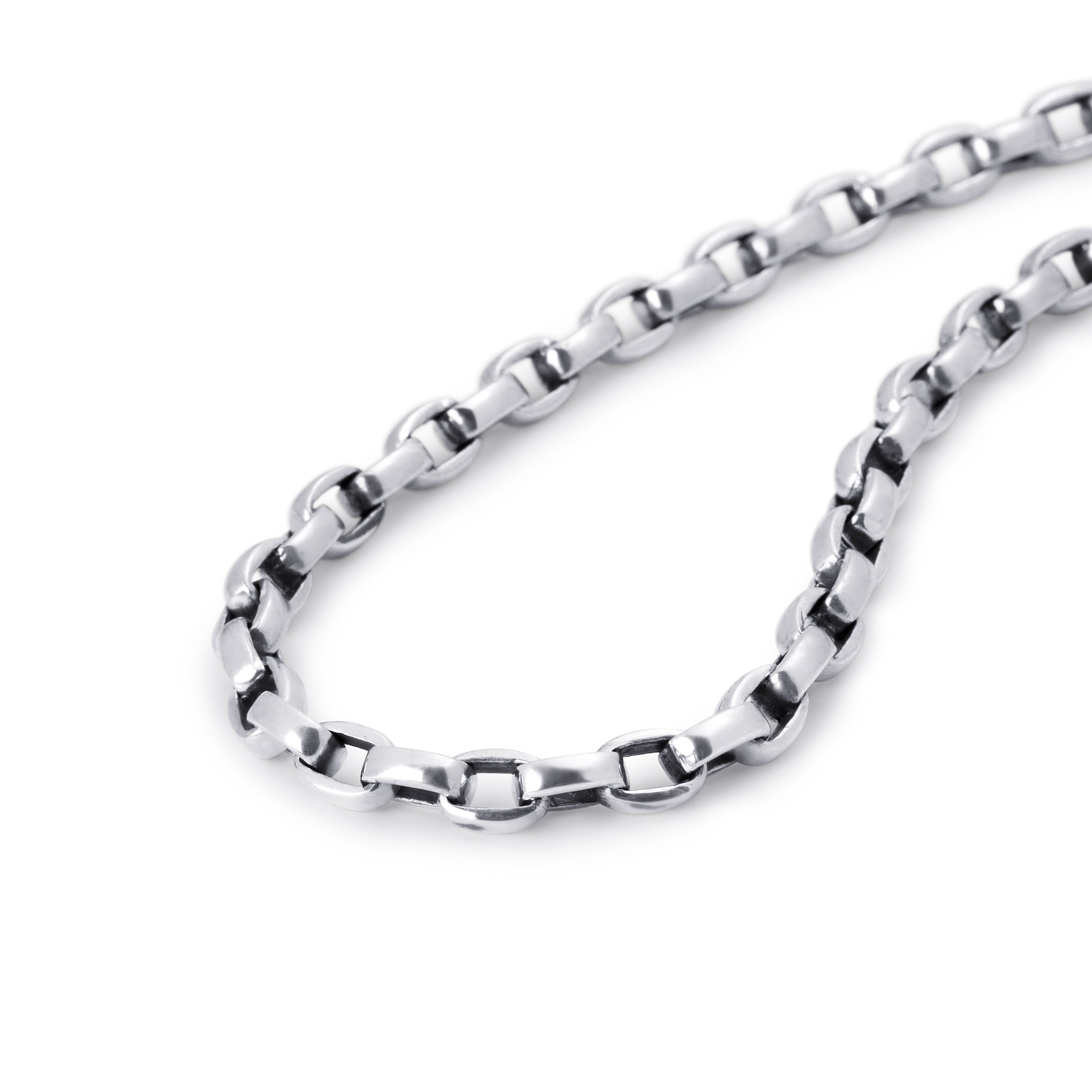 A close-up of a polished sterling silver chain necklace with a curb link pattern, arranged in a loop on a clean white background.