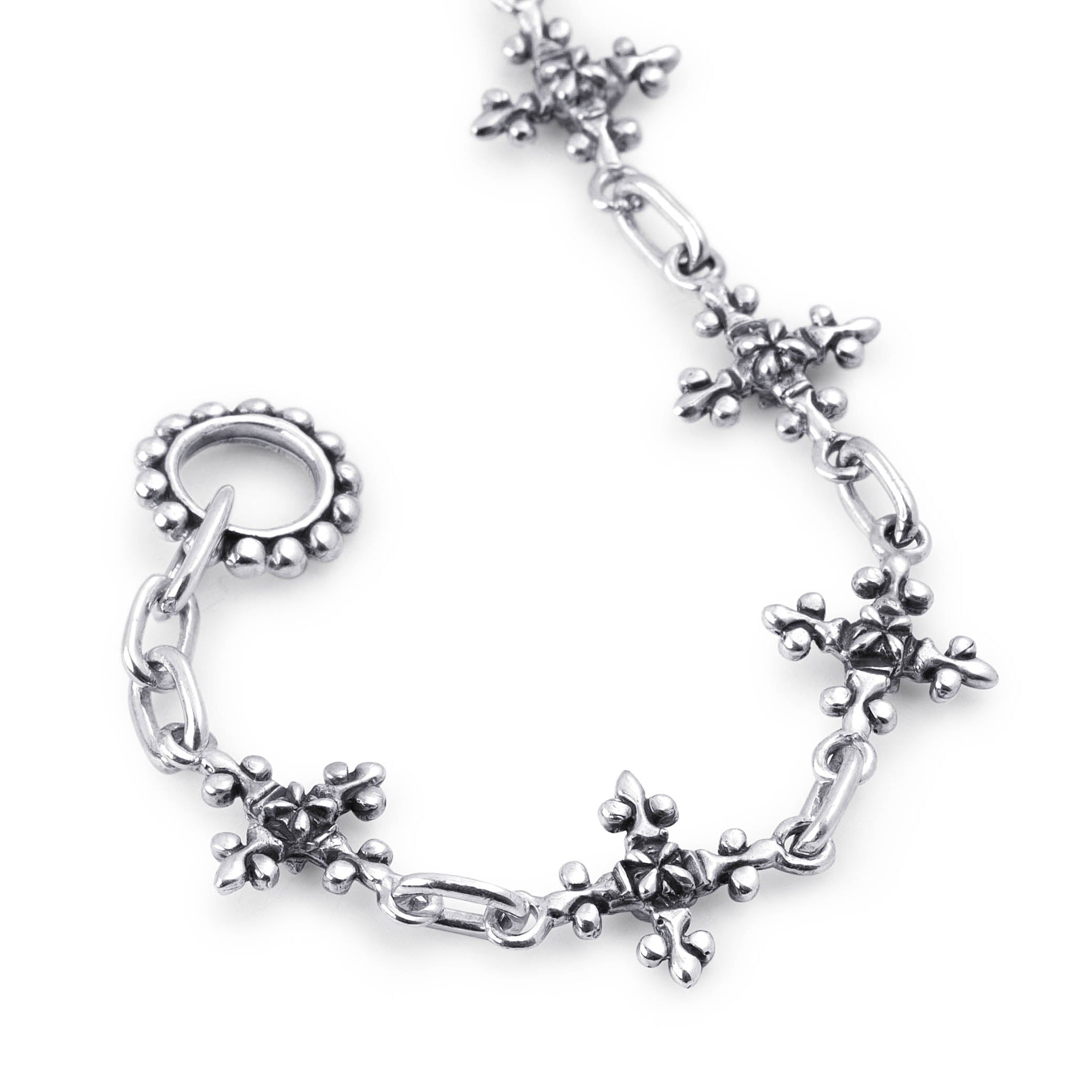 Close-up of the Antique French Cross bracelet showing sculpted silver cross links, oval connectors and a beaded clasp ring.