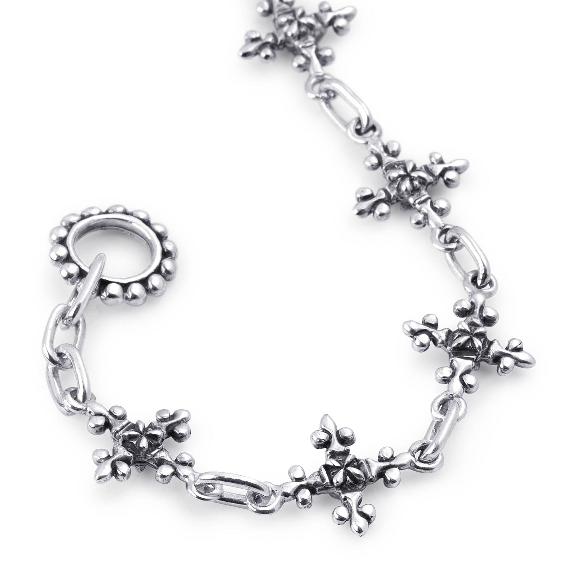 Close-up of the Antique French Cross bracelet showing sculpted silver cross links, oval connectors and a beaded clasp ring.