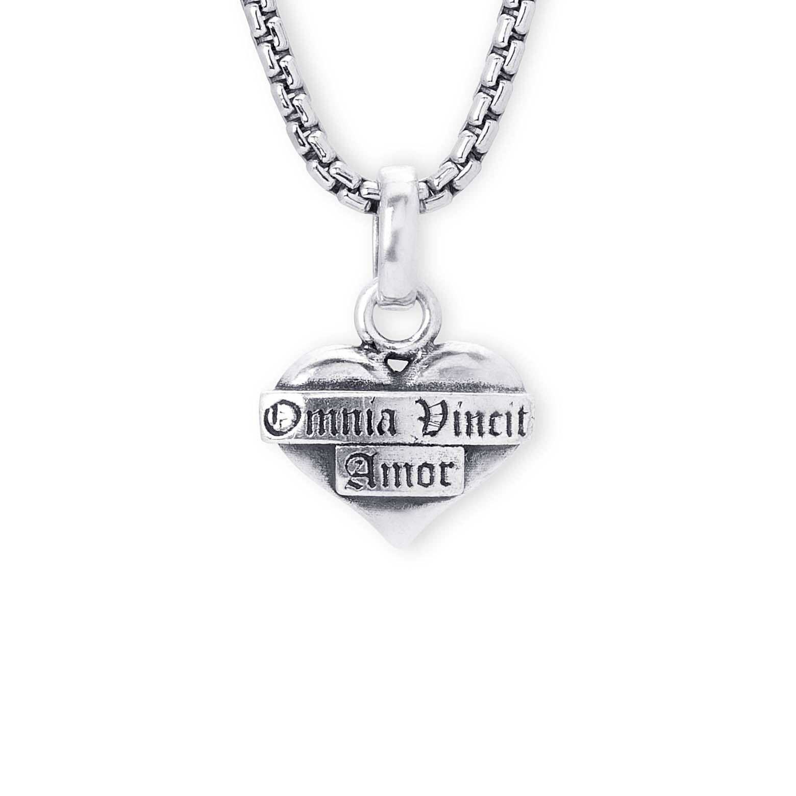 A silver heart pendant necklace engraved with the gothic text 'Omnia Vincit Amor' on a white background.