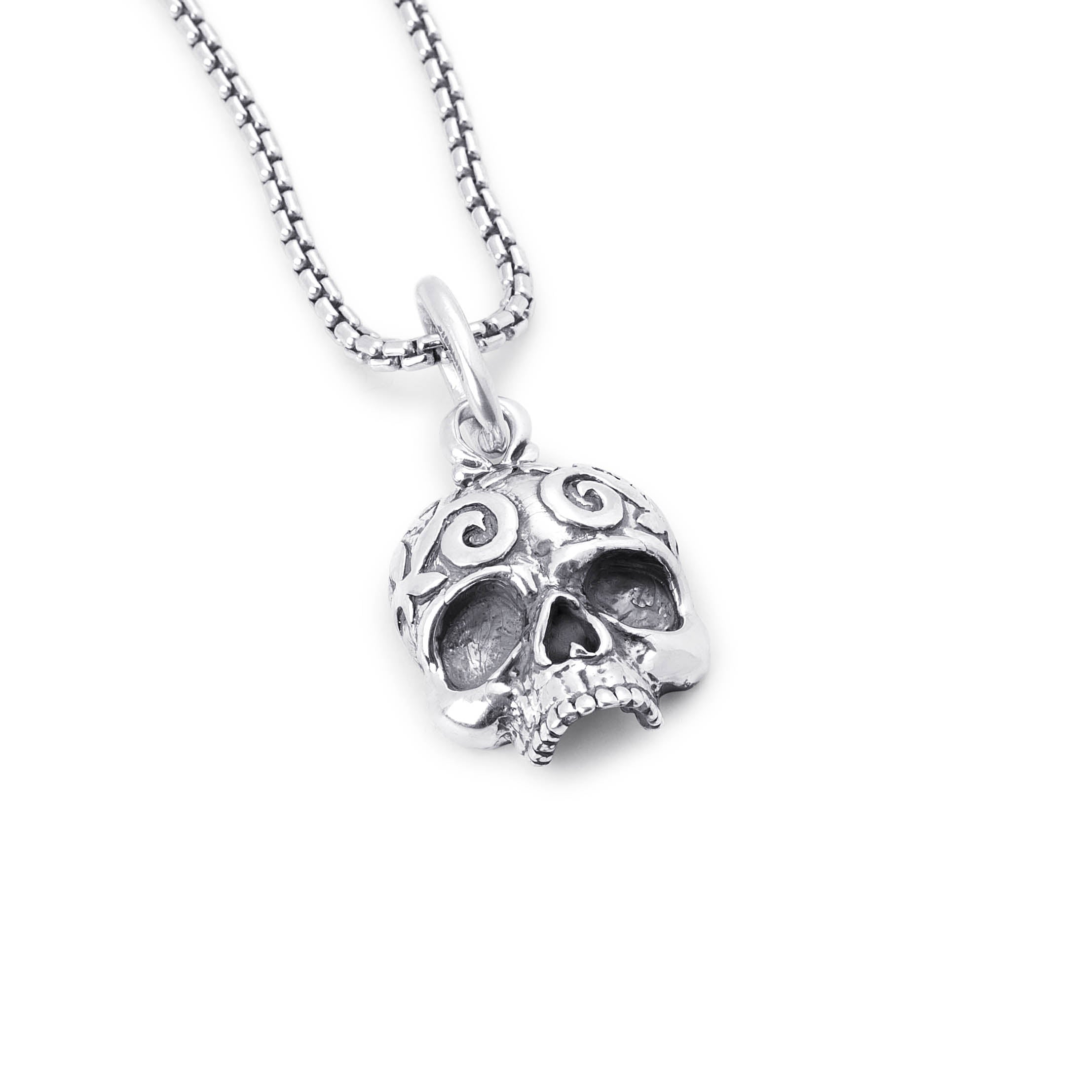 A sterling silver skull pendant necklace with intricate scrollwork details, hanging from a matching box chain against a plain white background.
