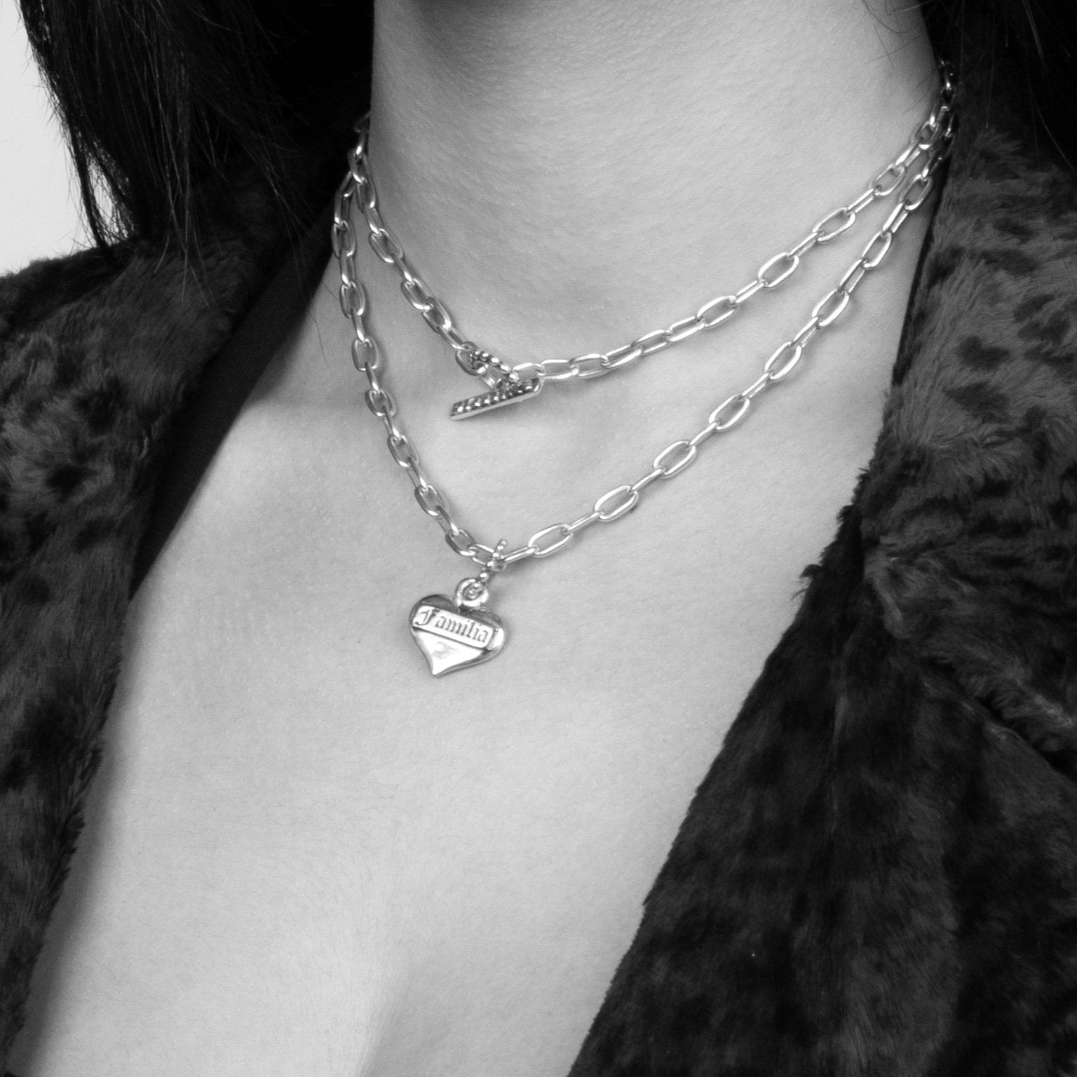 Solid Sterling Silver Classic Heart Pendant with Familia etched on the face being worn by a model