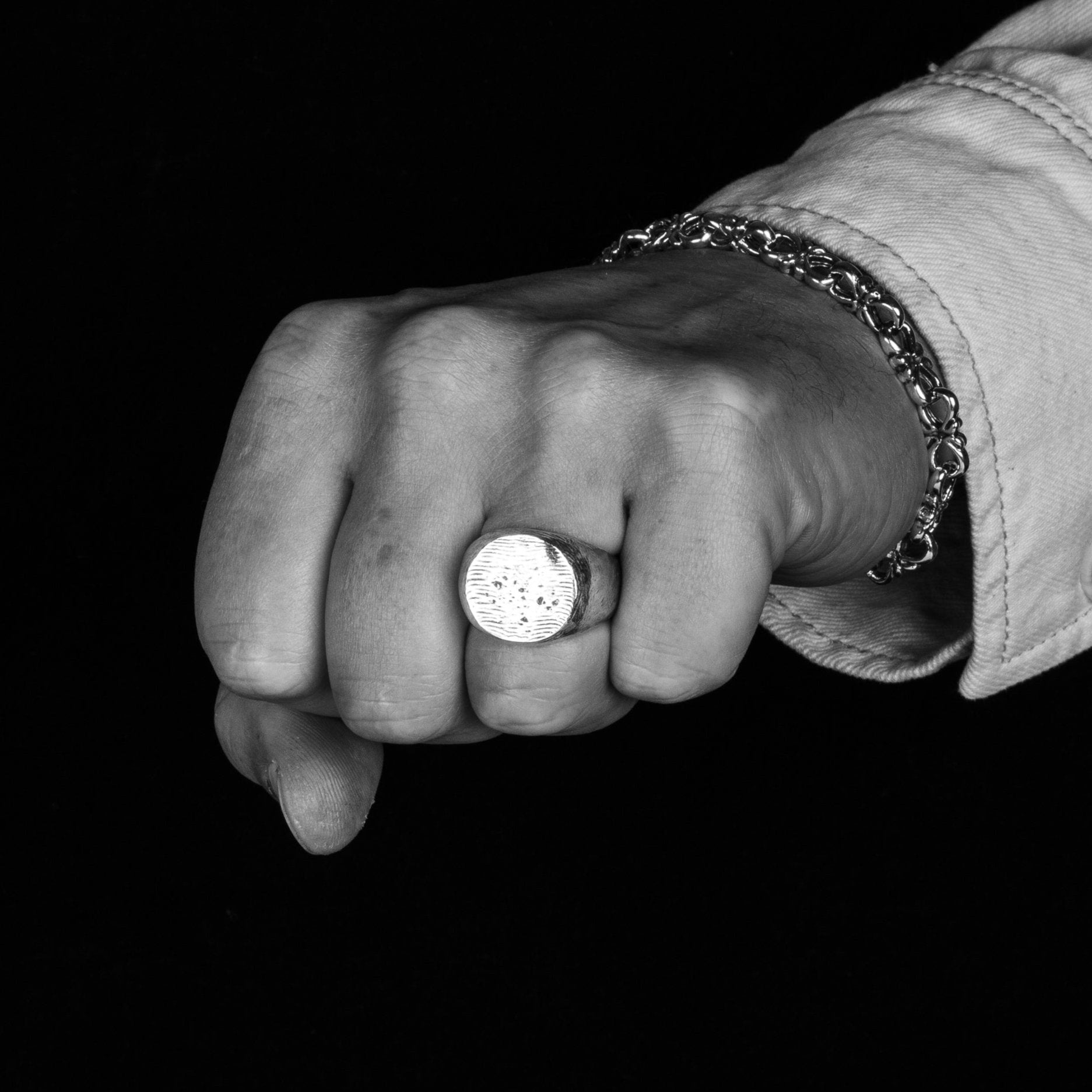 Men's hand wearing the Forged Signet Ring In Sterling Silver on his ring finger