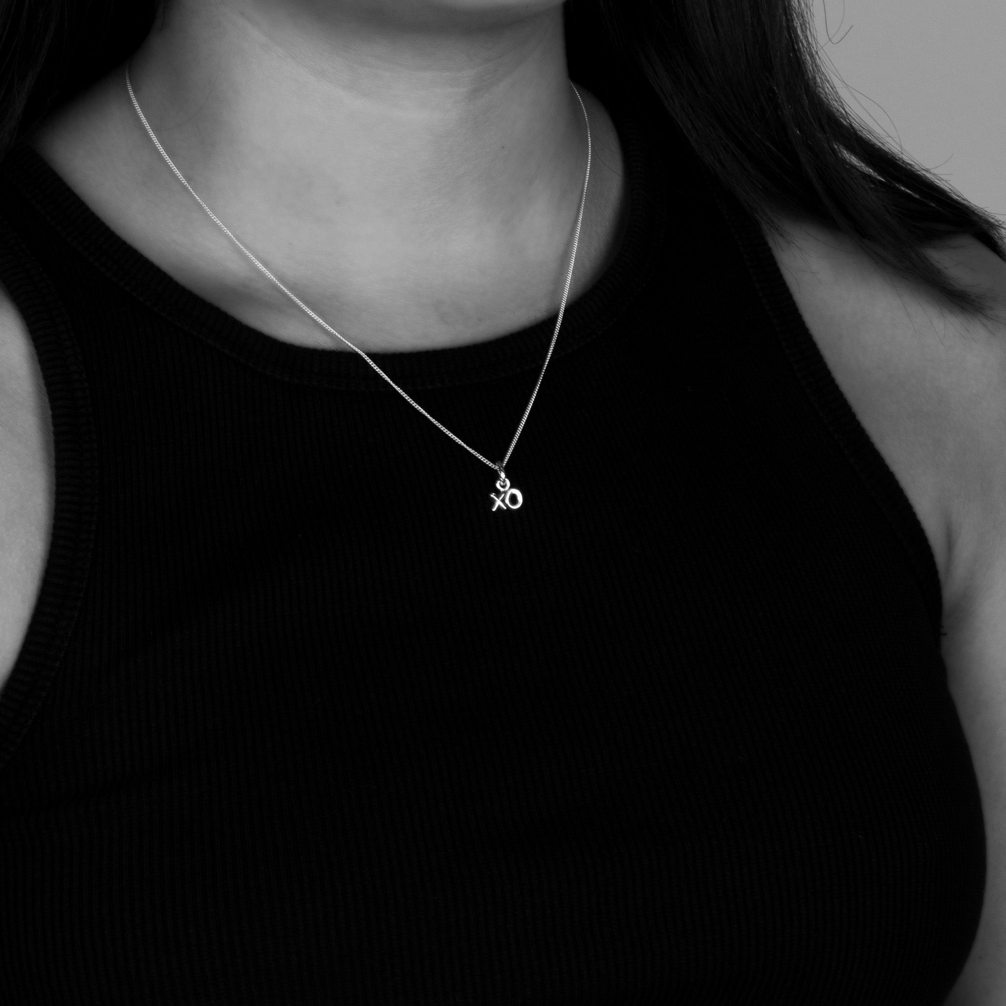 Model shot of the petite xo pendant on a fine chain. All sterling silver.