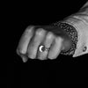 man's hand clenched in a fist wearing the Small Forged Rose Signet Ring in Sterling Silver