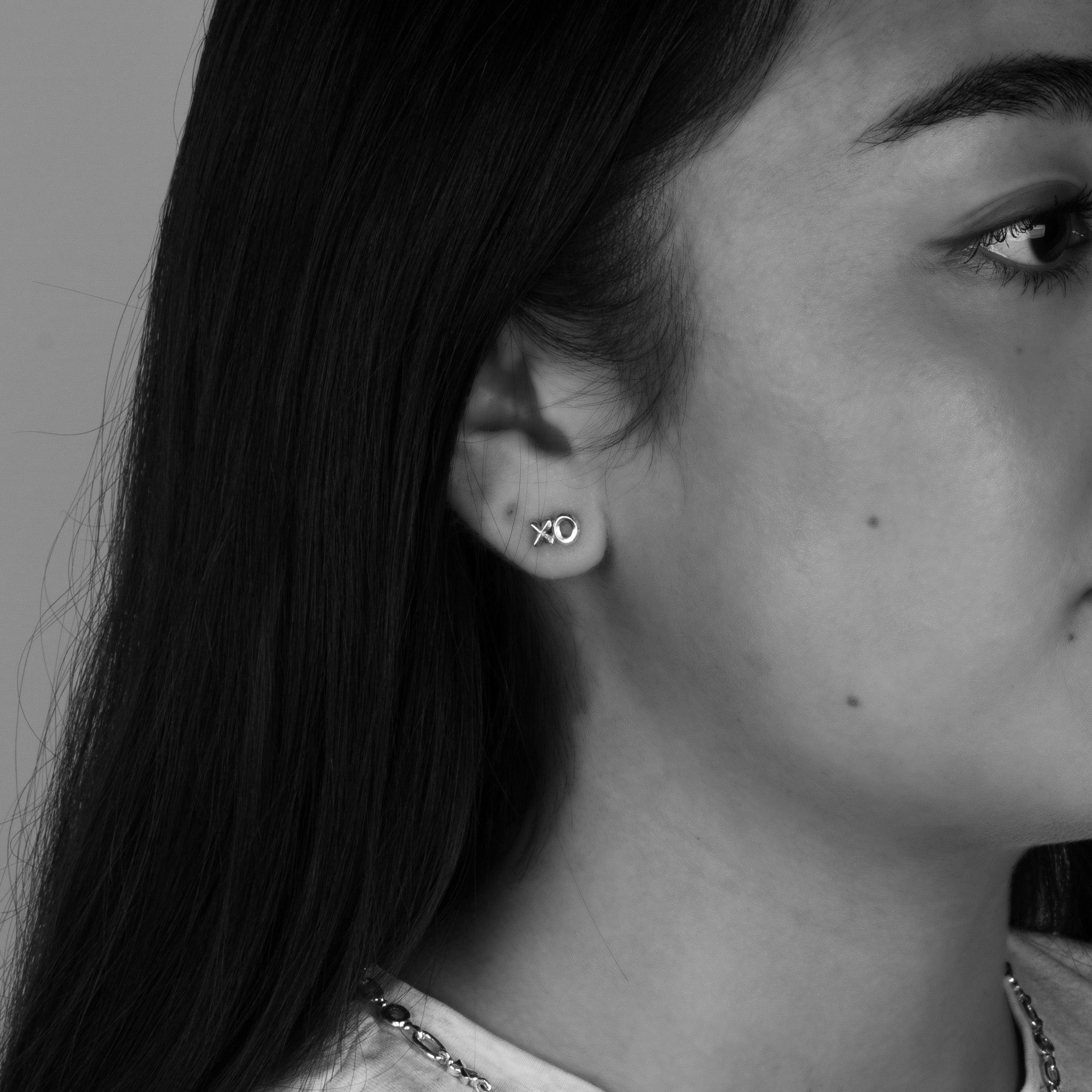 Petite XO Stud Earrings in Sterling Silver, 4mm worn on a female model's ear.