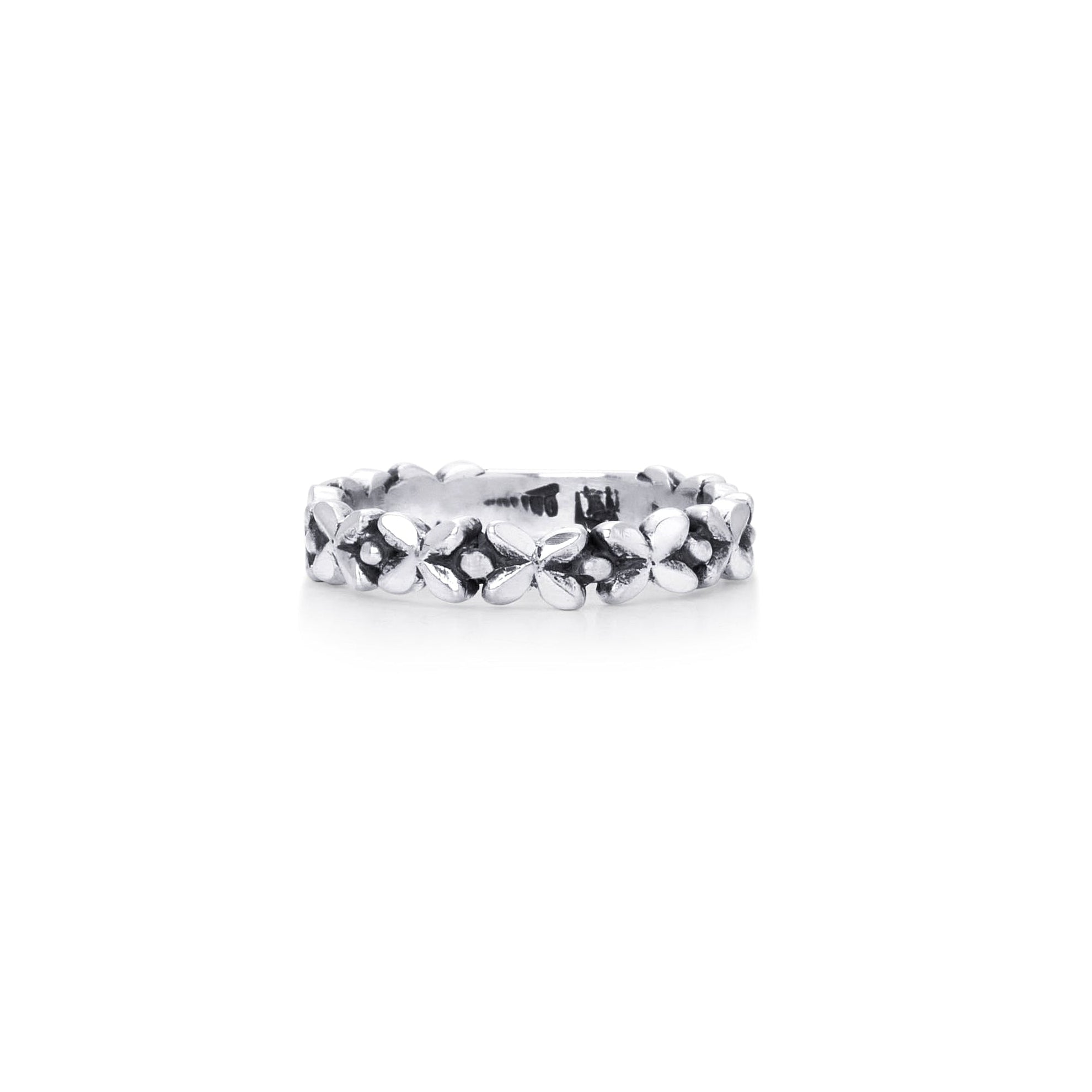 A silver textured band ring with a row of small, floral accents, shown on a plain white background.