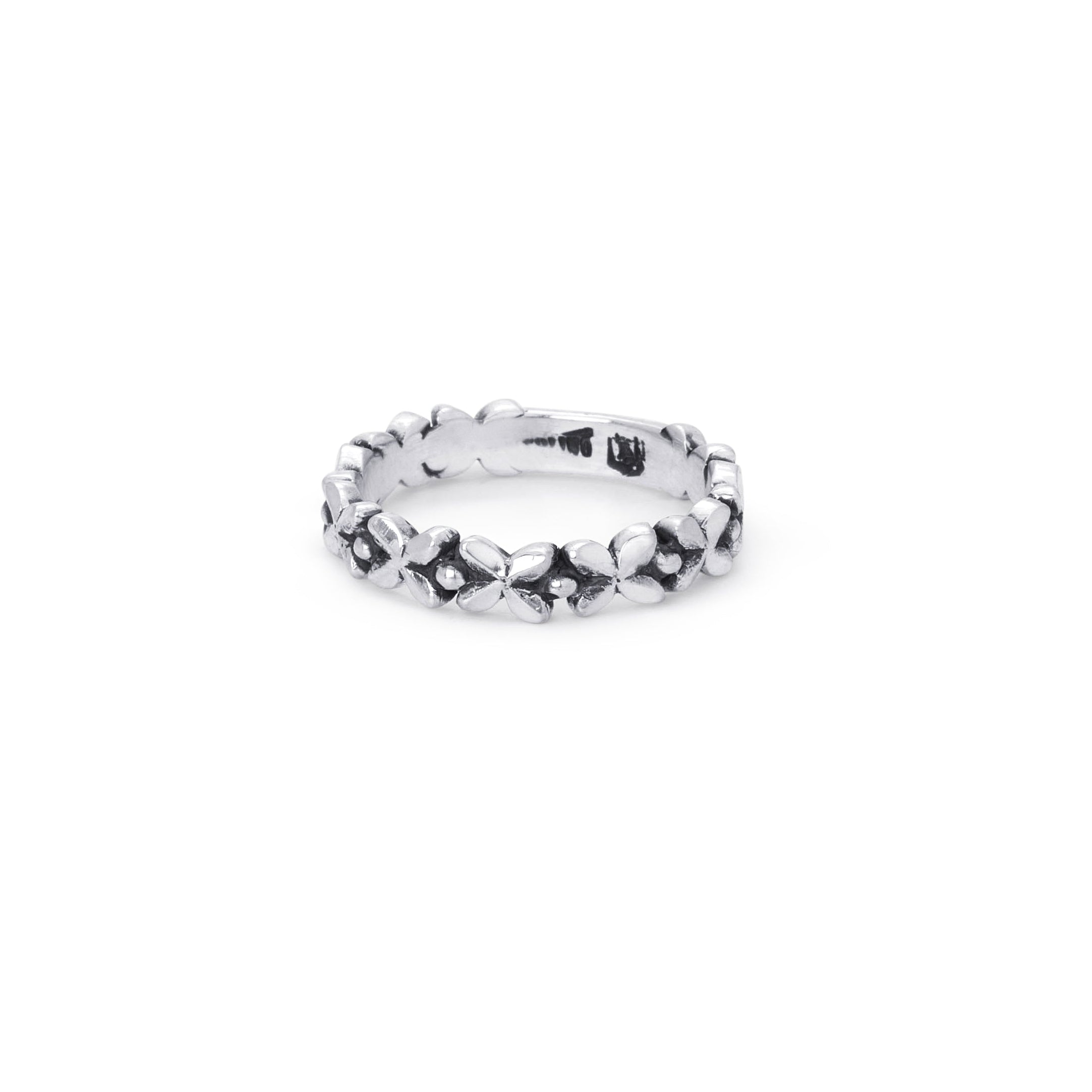 Silver ring with gfloral accents on a white background with measurement scale