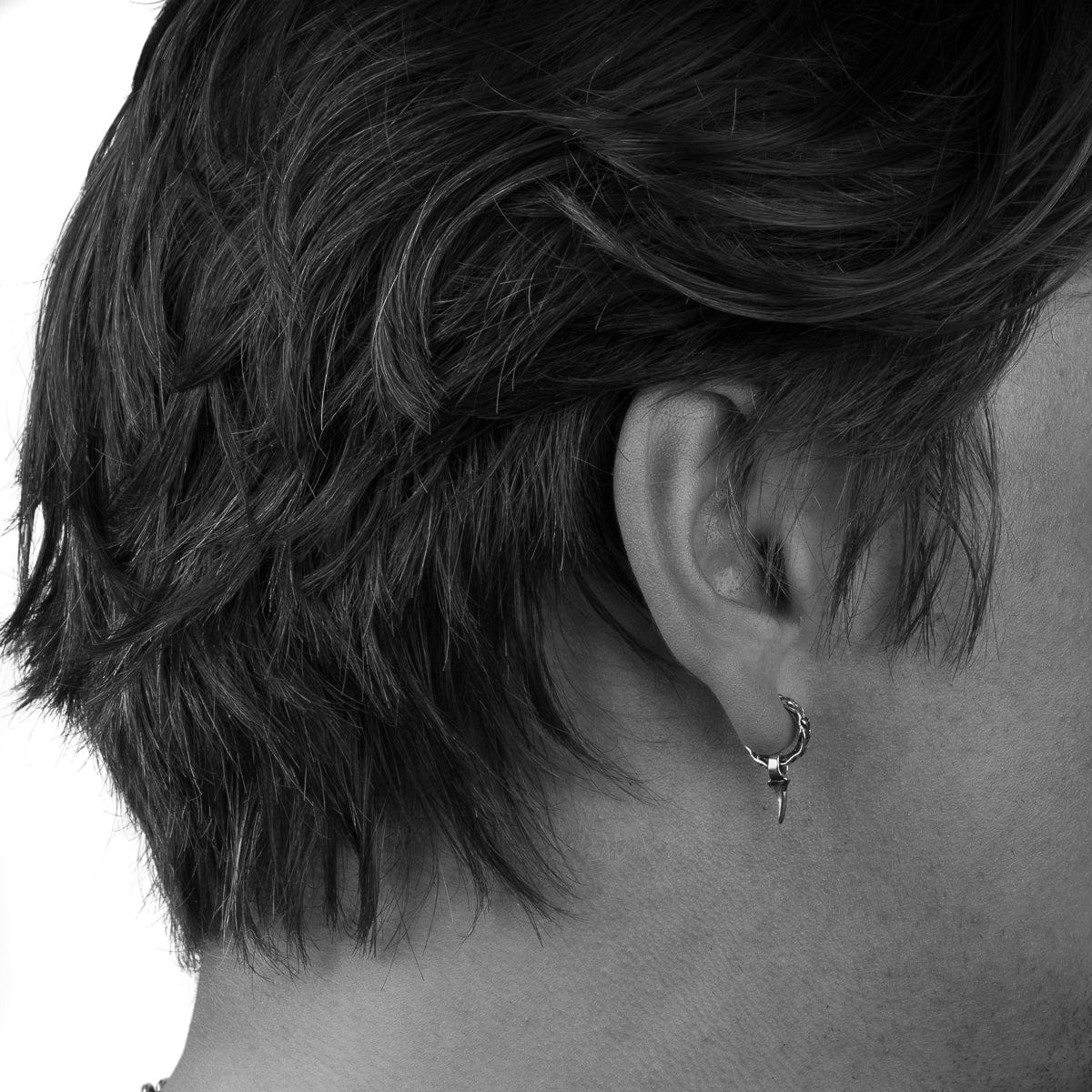 Small hoop stud with vine texture, Hanging thorn charm on male earlobe.