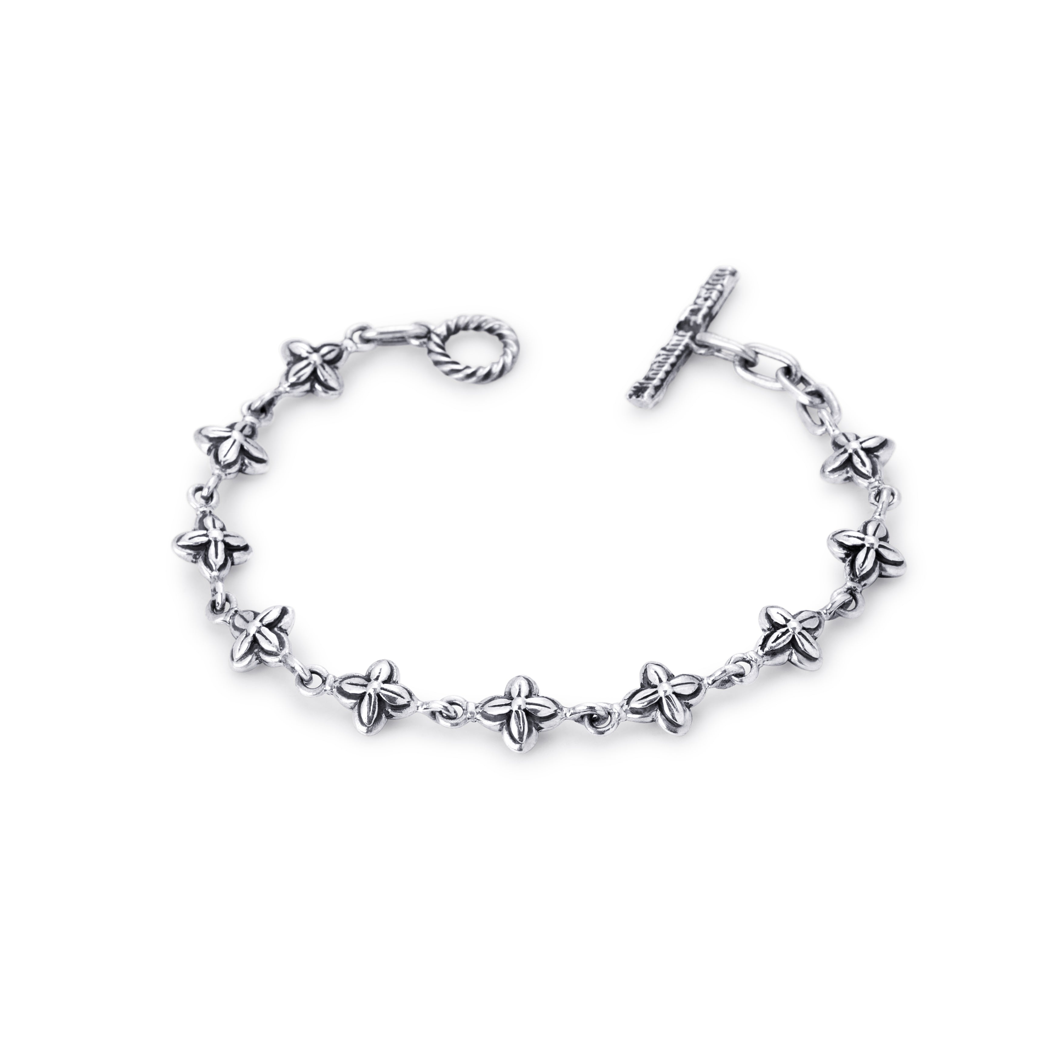 A sterling silver chain bracelet featuring small five-petal flower charms spaced along the link chain, with a twisted ring clasp and a toggle clasp on a plain white background.