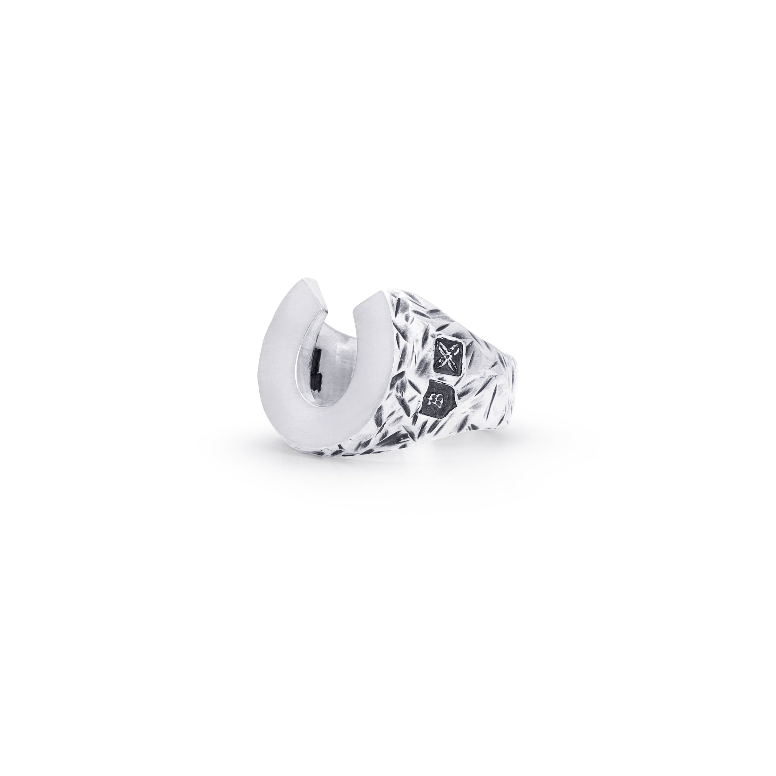 A silver-toned geometric ring with a textured, faceted band and a smooth crescent-shaped front, shown on a plain white background.