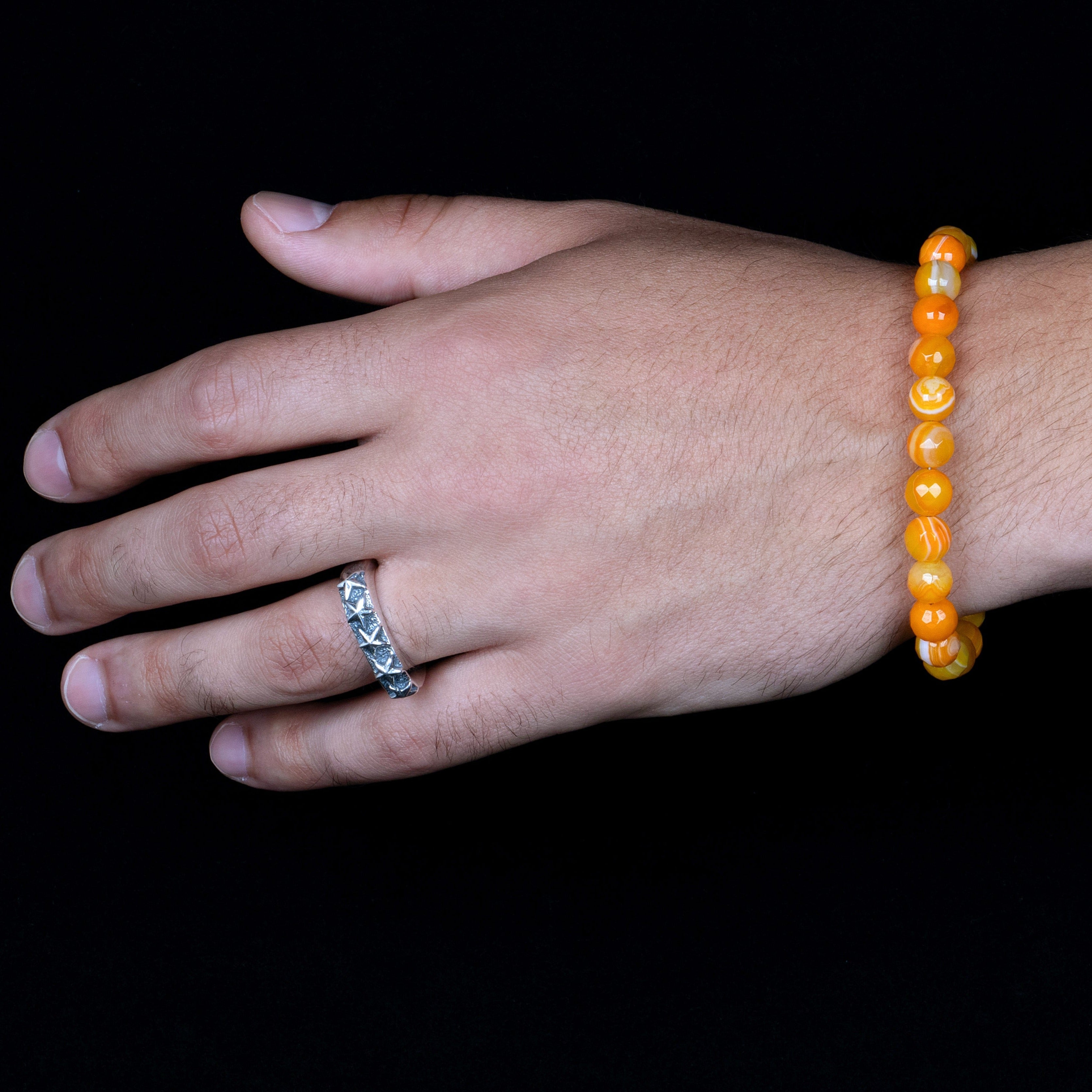 Faceted Mango Quartz beads on a stainless steel cable with Sterling silver T clasp. Shown on hand model.