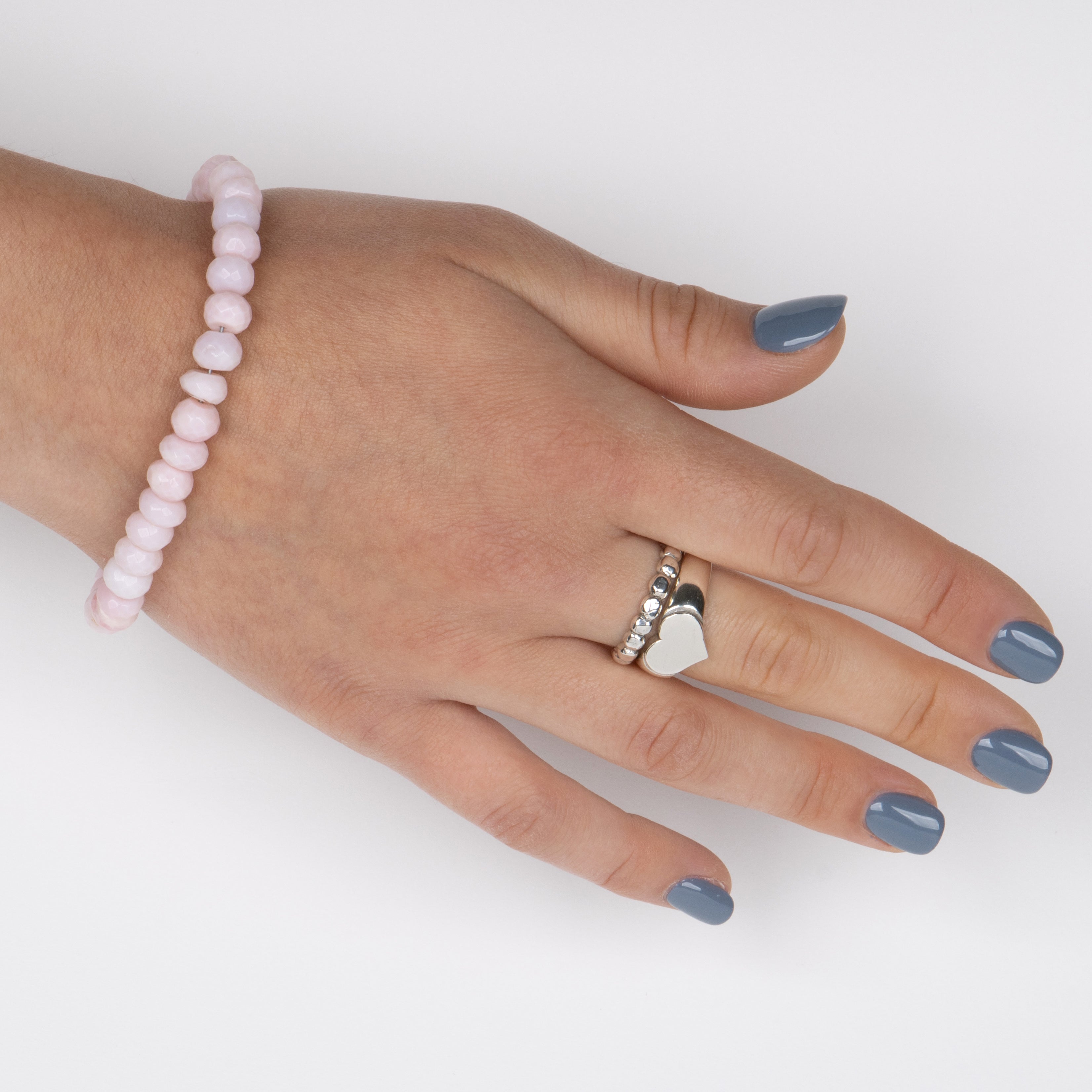 Faceted Pink Peruvian Opal beads on a stainless steel cable with Sterling silver T clasp. Shown on Hand Model.