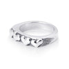 Solid sterling silver band with four hearts exposed on the top. Pitting surrounds the hearts on the top. 45 degree view of the Ring