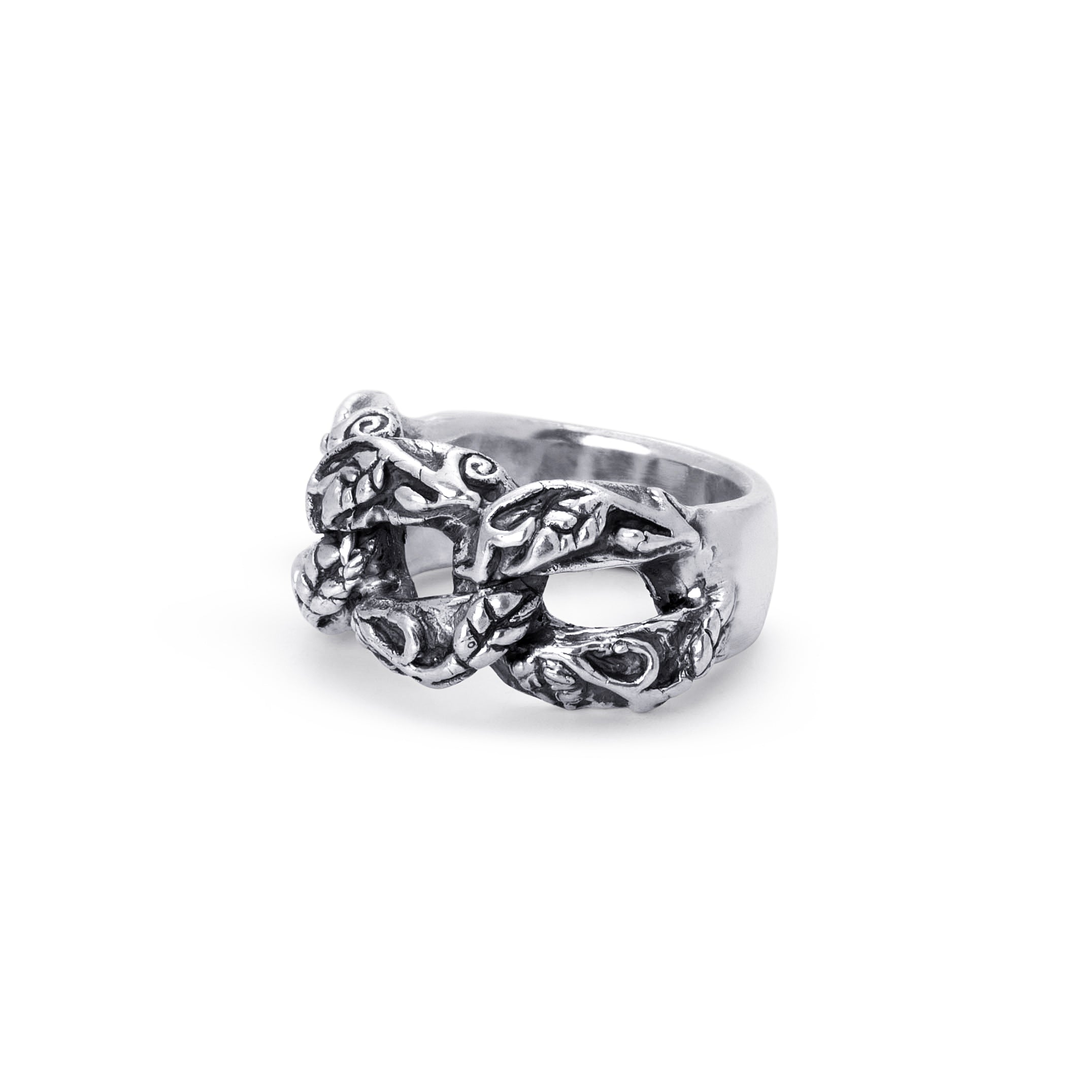 A silver-toned metal ring featuring an intricate, raised knotwork or leaf-like pattern across the band, photographed on a clean white background.