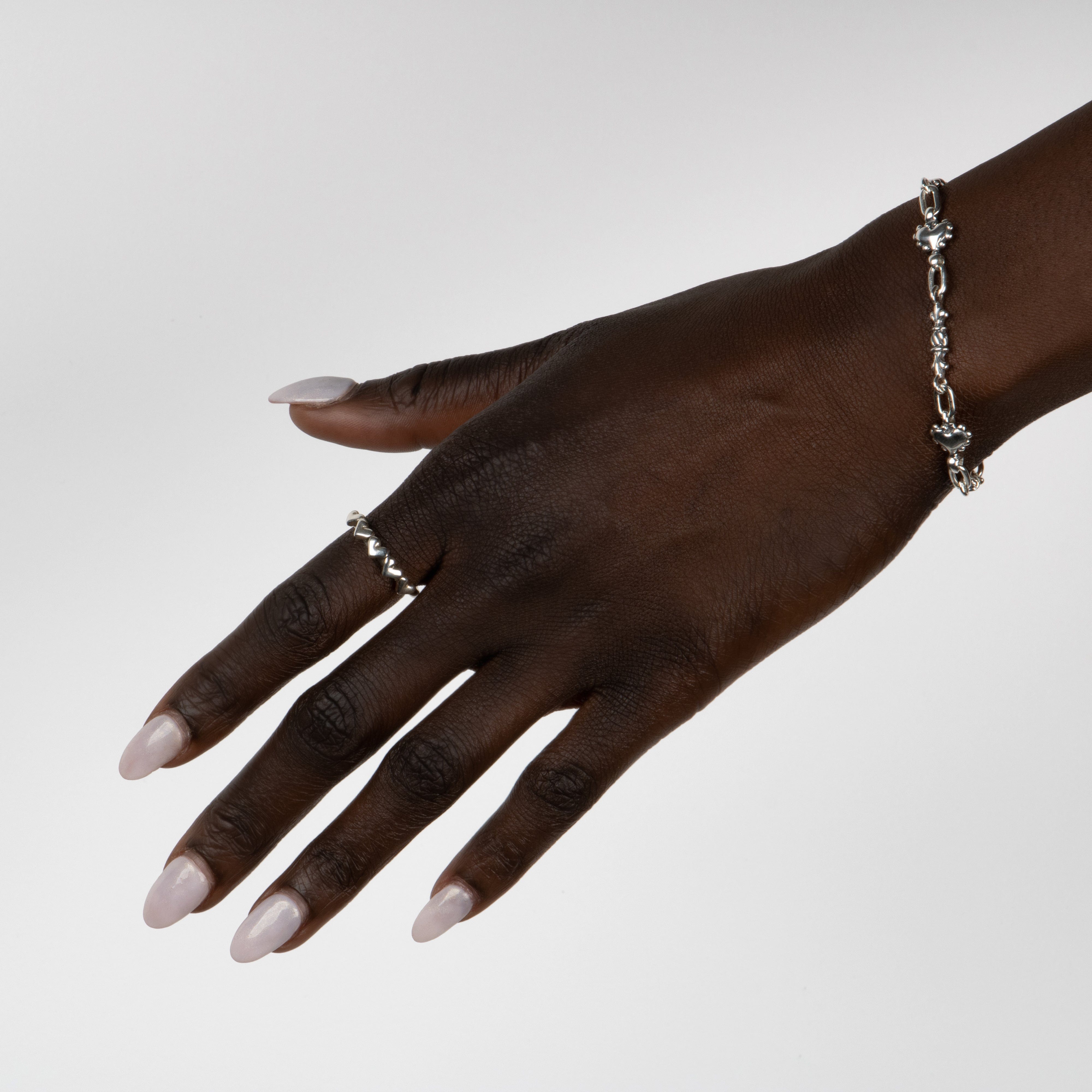 Women's Hand wearing our pillar and Beaded Heart Link Bracelet in Sterling Silver